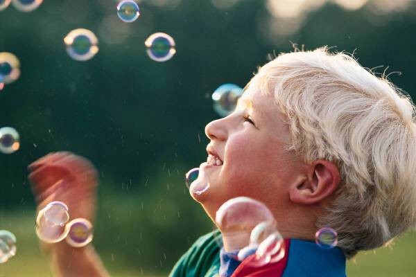 enfant jouant avec des bulles de savon